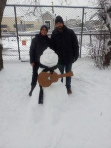 Brad Rau and Evelyn Molina building a guitar playing snowman in Boston. 